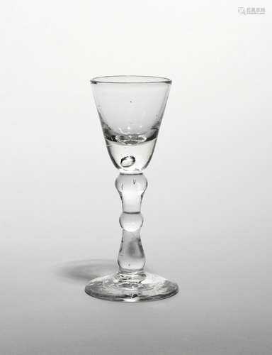 A small baluster wine glass c.1740, the rounded funnel bowl raised on a slender baluster stem with