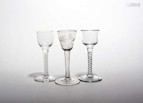 Three small wine glasses c.1760, one with a rounded funnel bowl engraved with a flower raised on a