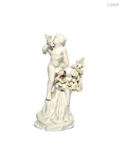 A Plymouth white-glazed figure of a putto c.1770, standing on top of a tall rocky base beside a