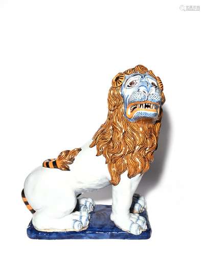 A large French faïence figure of a lion late 19th/early 20th century, perhaps Rouen, seated with