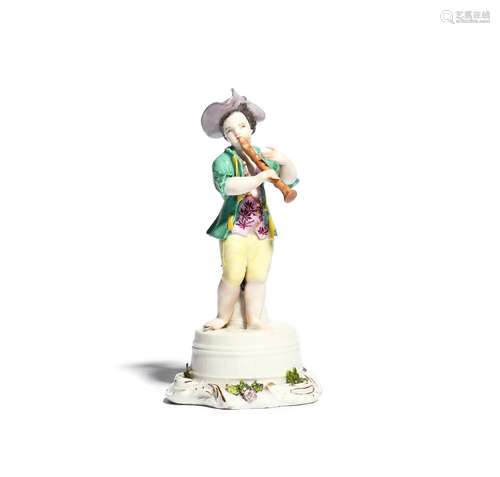 A Meissen figure of a young musician mid 18th century, modelled as a boy standing barefoot on top of