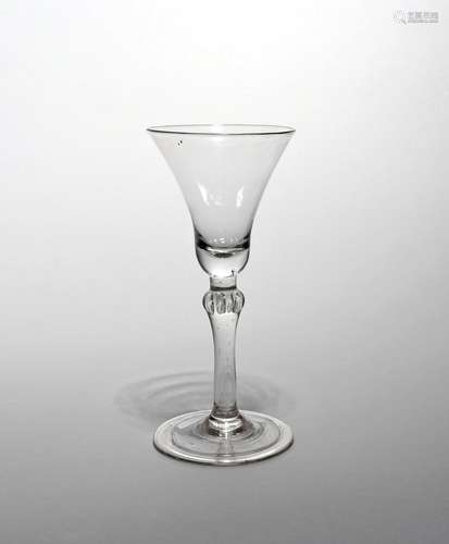 A balustroid wine glass c.1740, with a generous bell bowl raised on a plain stem with a beaded