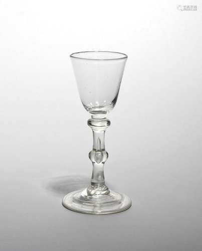 A wine glass c.1750, with a small rounded funnel bowl raised on a double-knopped stem above a folded