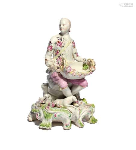 A large Derby sweetmeat figure c.1756, modelled as a gentleman seated with crossed ankles, a shallow