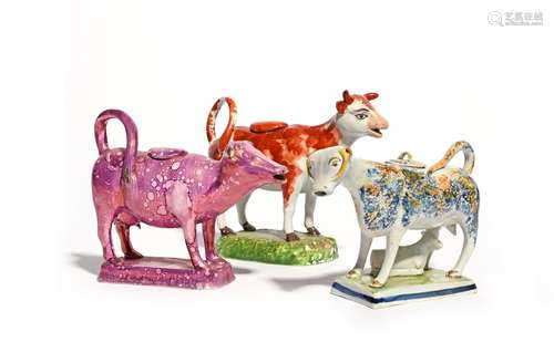 Three pearlware cow creamers and covers 19th century, one Pratt ware and sponged ion blue and ochre,