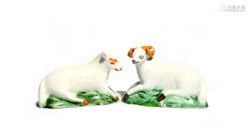 A pair of Yorkshire pearlware sheep c.1800, recumbent and modelled with heads slightly turned,