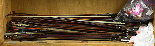 One shelf of approximately (59) violin bows