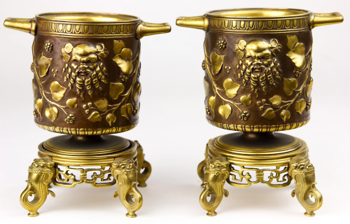 A pair of Grand Tour style gilt and patinated urns on
