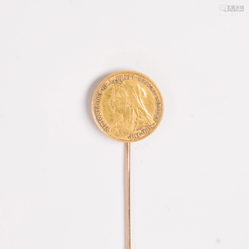A gold coin and fourteen karat gold stick pin