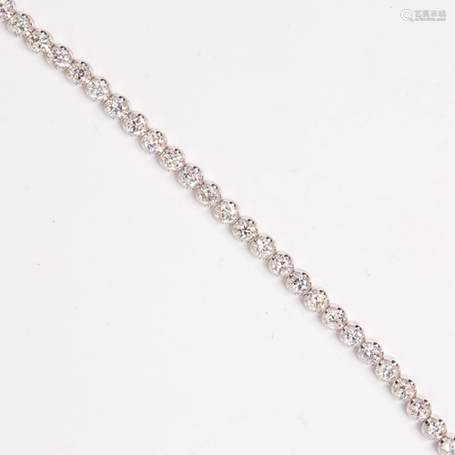 A diamond and fourteen karat white gold bracelet