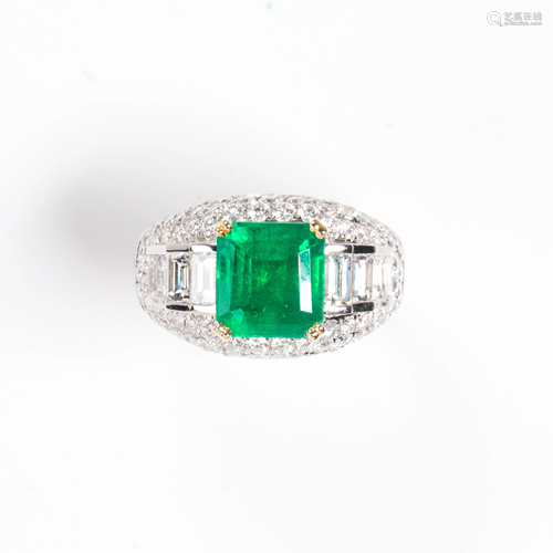 An emerald, diamond and eighteen karat white gold ring