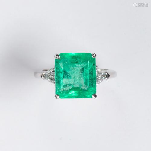 An emerald, diamond and platinum ring