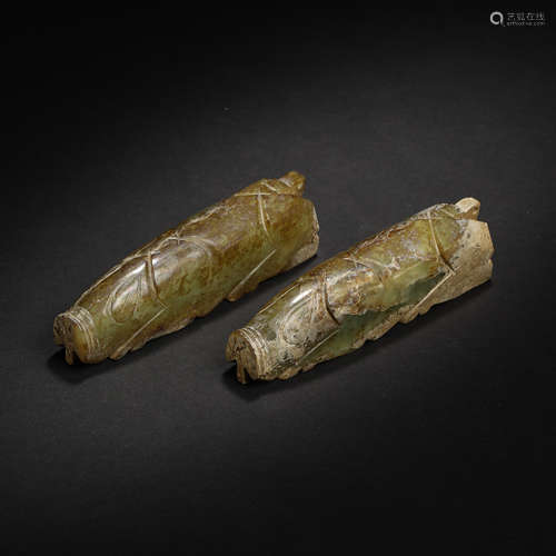 A PAIR OF CHINESE HAN DYNASTY HETIAN JADE PIGS HOLDINGS