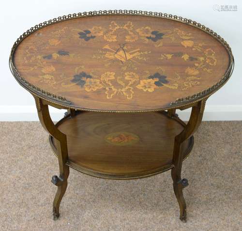 AN EDWARDIAN OVAL MAHOGANY AND MARQUETRY ETAGERE, C1905, THE TOP DECORATED WITH A MUSICAL TROPHY,