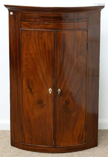 A GEORGE III BOW FRONTED MAHOGANY AND LINE INLAID HANGING CORNER CUPBOARD, EARLY 19TH C, THE PAINTED