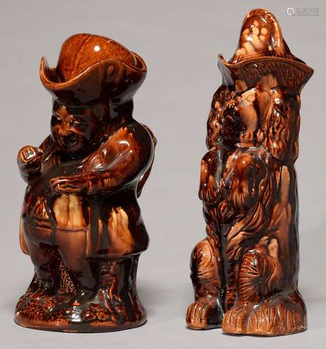 A VICTORIAN TREACLE BROWN GLAZED EARTHENWARE BEGGING SPANIEL JUG AND COVER AND A SIMILAR