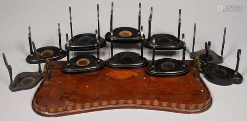 TEN EBONISED WOOD CUP AND SAUCER STANDS AND A DAMAGED EDWARDIAN INLAID MAHOGANY GALLERY TRAY