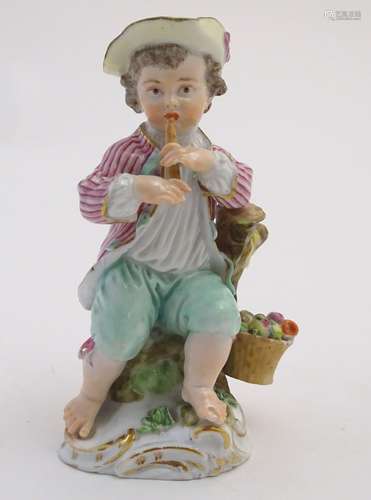 A Continental porcelain figure of a boy playing a musical instrument, seated on a naturalistic