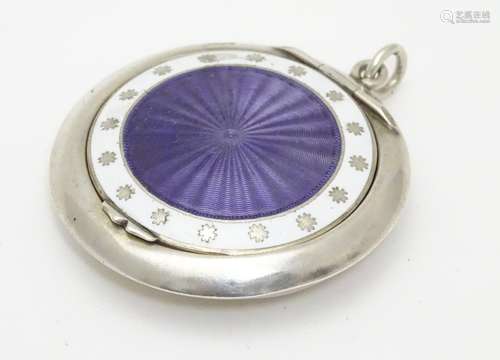 A silver compact with purple guilloche enamel decoration to lid bordered by white enamel. Hallmarked