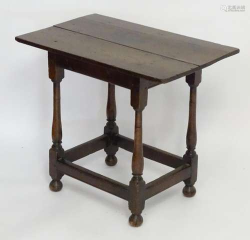 A 17thC and later side table with an overhanging top above four turned tapering legs terminating