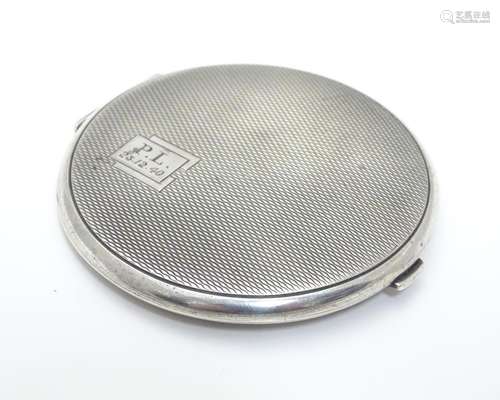 An Art Deco silver powder compact with engine turned decoration. Hallmarked Birmingham 1938 maker