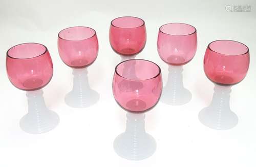 A set of six early 20thC cranberry hock glasses with ribbed milk glass stem bases, each 5 1/4