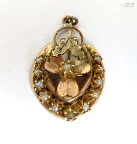 A 19thC gold and gilt metal pendant of horse shoe form with seed pearl detail. 3 /4