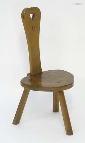 An Alan ' Acornman ' Grainger spinning stool of oak peg jointed construction, with a pierced heart