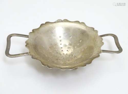 A silver tea strainer with twin handles. Hallmarked Birmingham 1944 maker E J Houlston 4 1/2