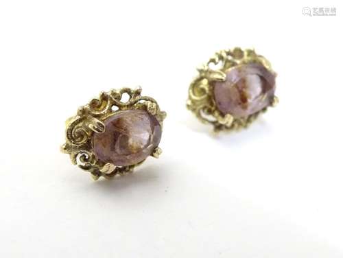 A pair of 9ct gold stud earrings set with amethyst. Approx 1/4