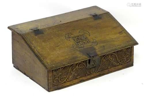 A late 17thC oak bible box with a carved sloped lad, with carved initials and date and having floral