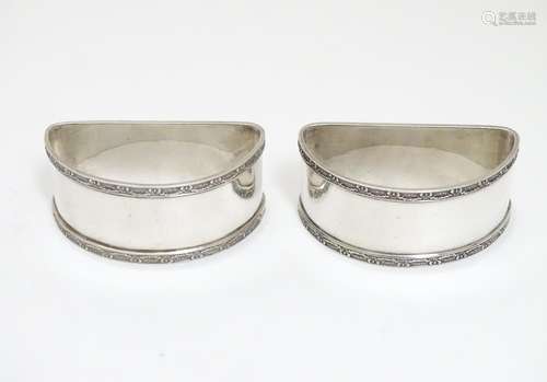 A pair of silver napkin rings of semi circular form hallmarked Birmingham 1932 maker E & N Speak