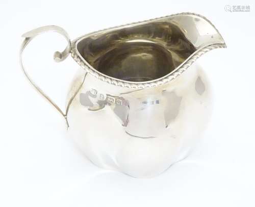 A silver cream jug of quatrefoil form, the rim with gadrooned decoration. Hallmarked Birmingham 1903