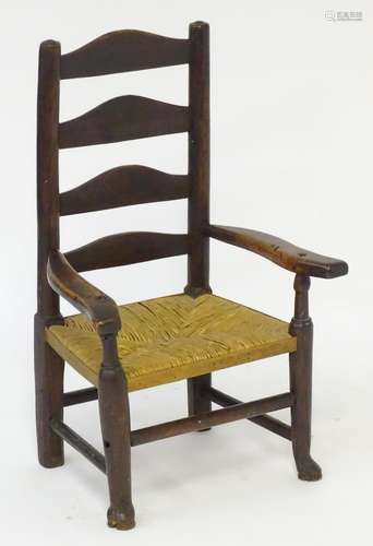 A late 18thC Georgian ladderback childs chair with an envelope rush seat and standing on squared