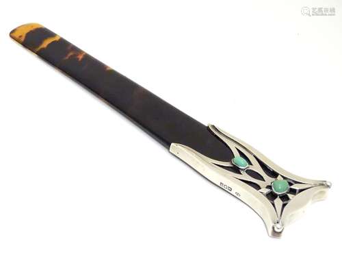 An Arts and Crafts tortoiseshell page turner with silver mounted handle with green cabochon detail