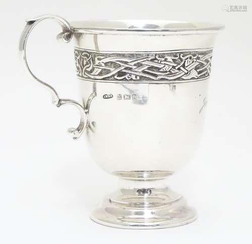 A Silver mug decorated with a frieze bearing Art Nouveau / Arts and crafts design, raised on a