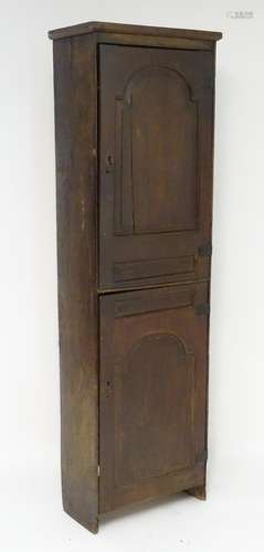 An early 18thC narrow oak cupboard with two carved panelled doors and original wrought iron