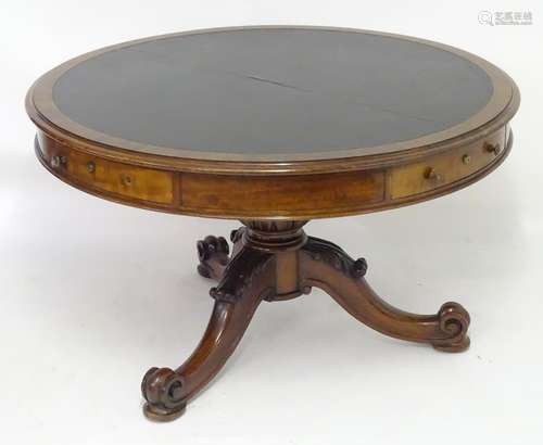 A mid 19thC mahogany drum library table with a circular moulded top containing an inset leather