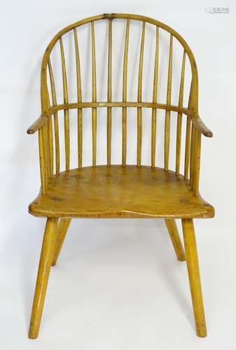 A late 18thC Windsor chair with a double bowed back and splayed arms above a shaped elm seat and