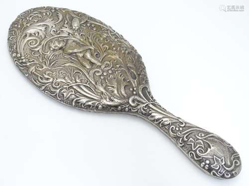 A silver backed hand mirror with moth, acanthus and cherub decoration. Hallmarked Chester 1901 maker