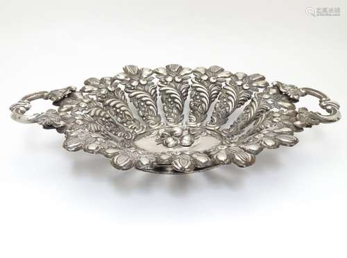 A late 19thC / early 20thC Continental white metal twin handled bowl with embossed fruit and