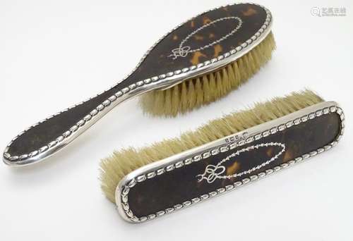 Two brushes with silver and tortoishell backs hallmarked Birmingham 1918. The largest approx 10