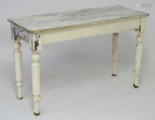 A late 19thC / early 20thC white painted side table with a rectangular planked top above four turned