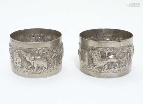 Two white metal napkin rings decorated with elephants, lions, tigers etc. Probably Indian Please