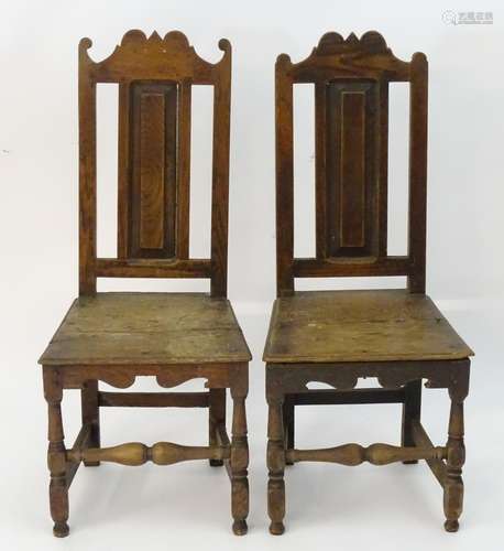 A pair of 17thC oak side chairs with shaped top rails, panelled backs and seats, standing on