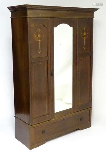 An early 20thC mahogany wardrobe with a moulded cornice above a satinwood inlayed carcass, having