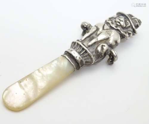 A mother of pearl rattle teether the handle formed as a circus lion. Hallmarked 1940 maker