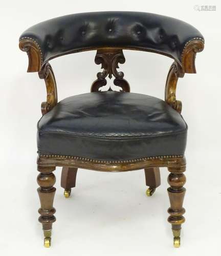 A mid 19thC mahogany captains chair with a deep buttoned leather backrest and leather upholstered