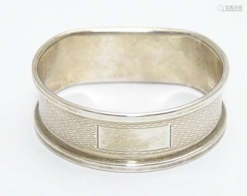 A silver napkin ring with engine turned decoration hallmarked Birmingham 1988 maker B& Co. Please