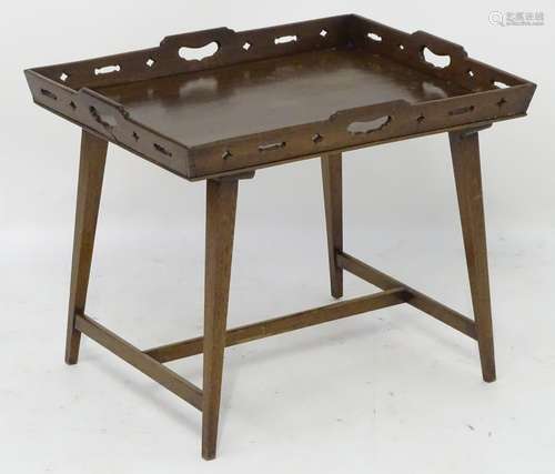 An early 19thC mahogany tray top table, with handle grips to each side and having pierced decoration